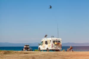 RV camping by the water on a Sunny day. Car with airbrushing on